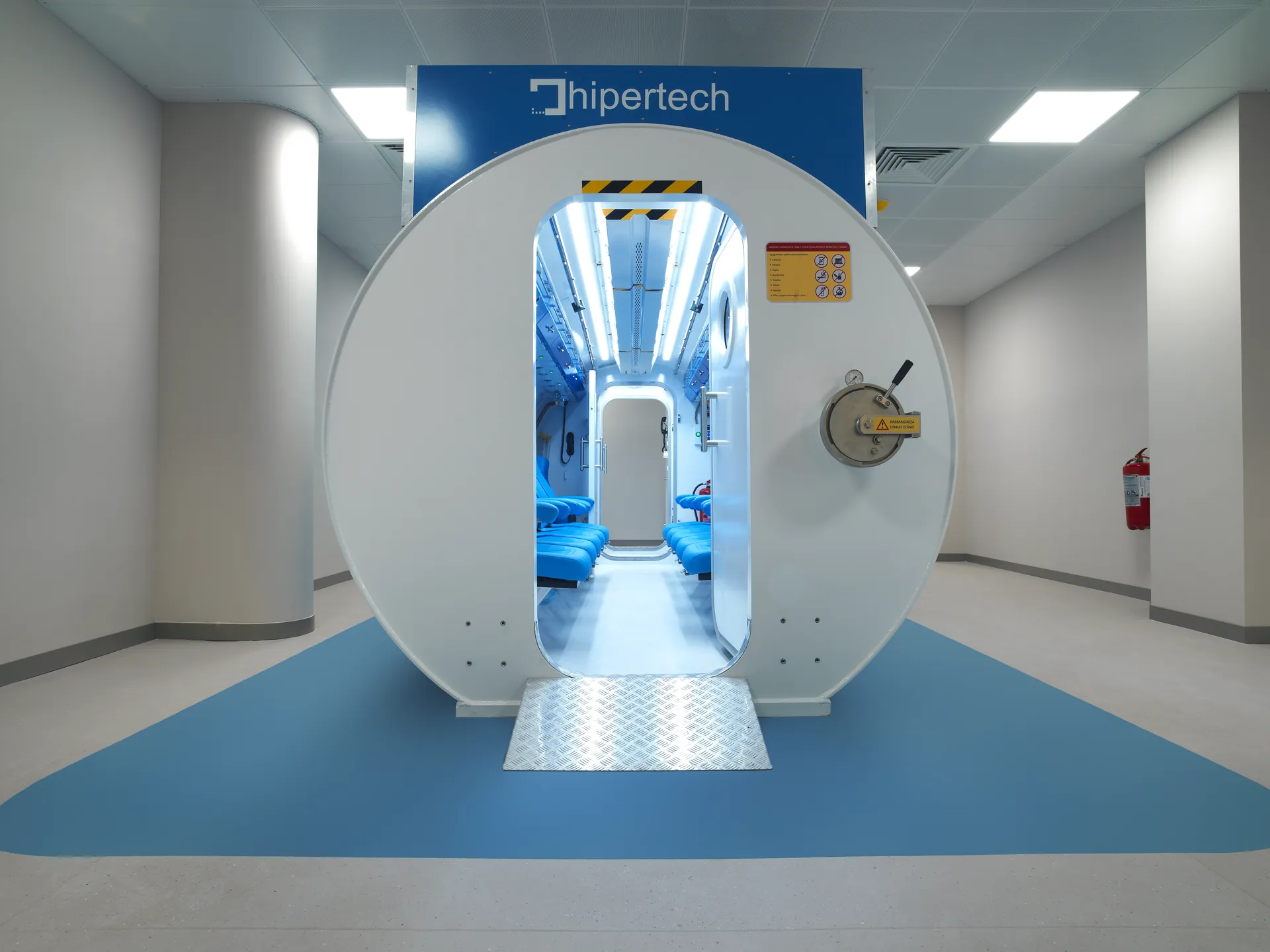 Hipertech multiplace hyperbaric chamber installed in a hospital corridor, hatch open to the interior